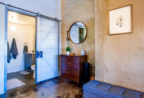 a bathroom with a sliding shower door and a mirror at Sterchi Lofts Getaway - Downtown Knoxville in Knoxville