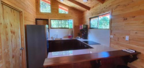 a kitchen with a counter top in a wooden cabin at Cabaña Tio King in Uvita
