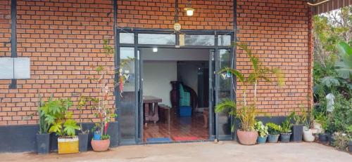 an open door of a brick building with potted plants at Manel Guesthouse and Restaurant in Sen Monorom