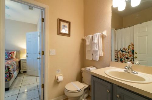 La salle de bains est pourvue d'un lavabo, de toilettes et d'un miroir. dans l'établissement Relaxing resort, spacious pool near Disney, à Davenport