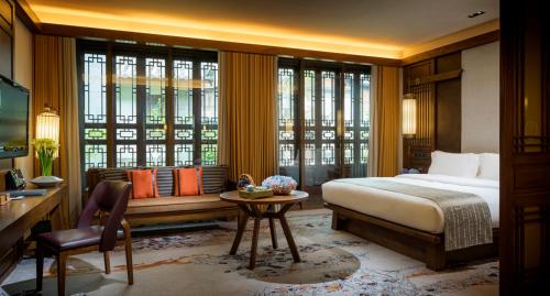 een slaapkamer met een bed, een bureau en een tafel bij InterContinental Lijiang Ancient Town Resort, an IHG Hotel in Lijiang