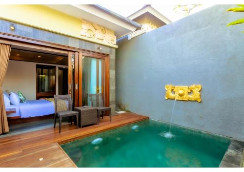 a room with a swimming pool and a bedroom at The Canggu Boutique Villas & Spa by ecommerceloka in Canggu