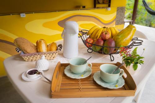 Green Area House في أبراو: طاولة مع كوبين وسلة فاكهة