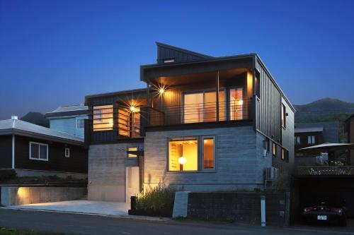 a house with a balcony on a street at night at Orchid Furano in Furano
