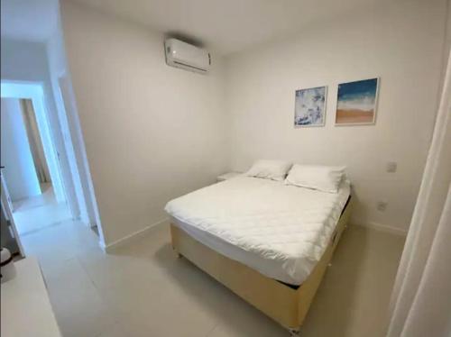 Praia Da CaueiraにあるFlat Praia da Caueira - Flat com piscina a 100m da praiaの白い部屋の小さなベッド1台