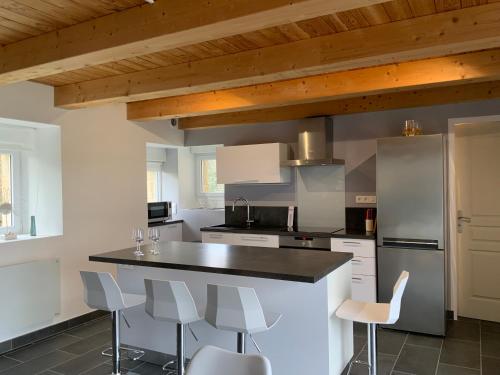 une cuisine avec un comptoir noir et des appareils électroménagers blancs dans l'établissement Maison TY Traon -, à Audierne