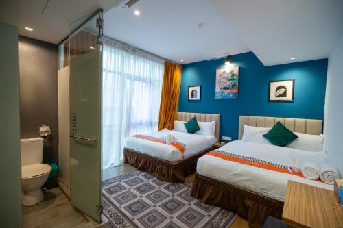 a hotel room with two beds and a toilet at Apollo Inn in George Town