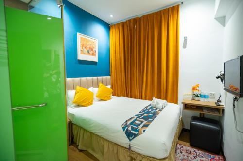 a bedroom with a bed with yellow and blue walls at Apollo Inn in George Town