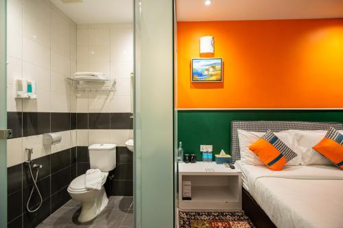 a small bathroom with a bed and a toilet at Link Hotel in George Town