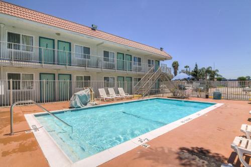 a swimming pool with a blue chair and blue chairs at Motel 6-Sepulveda, CA - Los Angeles - Van Nuys - North Hills in North Hills