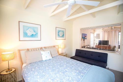 une chambre avec un lit bleu et une fenêtre dans l'établissement THE DUNES + 100M TO BEACH + POOL + EXCEPTIONAL LOCATION, à Point Lookout