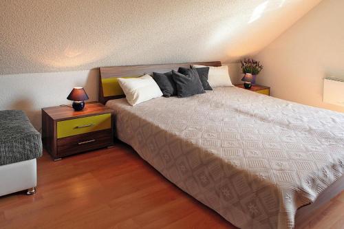 a bedroom with a large bed with pillows on it at Cottages at the Kummerower See, Verchen in Verchen