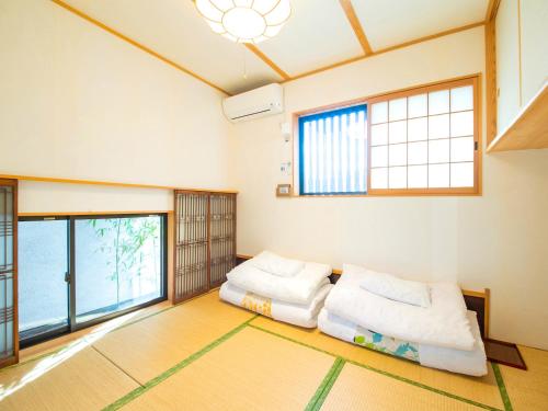 two beds in a room with windows at Guest House Wakabaya in Takamatsu