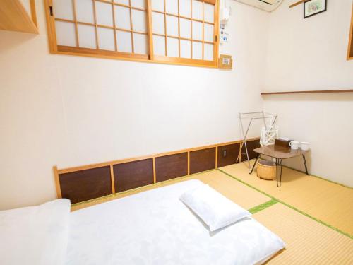 an empty room with a bed and a table at Guest House Wakabaya in Takamatsu