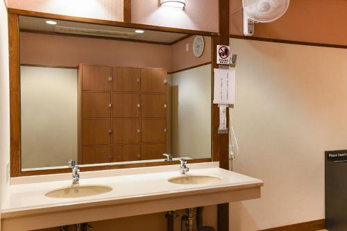 a bathroom with two sinks and a large mirror at Arima Onsen Koki in Kobe
