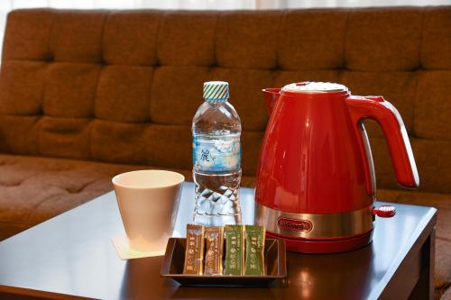a table with a coffee maker and a bottle of water at Arima Onsen Koki in Kobe