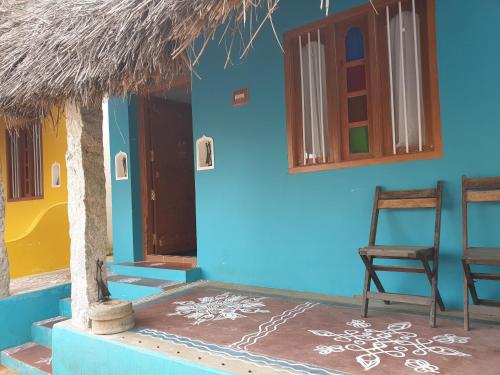 a blue house with a chair and a room at TANJORE HOME STAY in Thanjāvūr