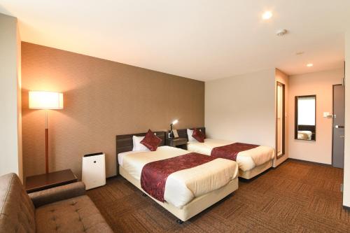 a hotel room with two beds and a couch at Arima Onsen Koki in Kobe