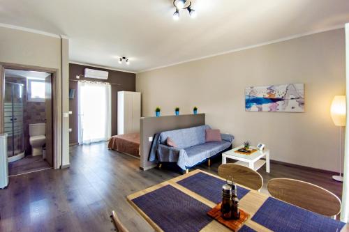 a living room with a couch and a bed at Maria's modern studio 5min from beach in Souda