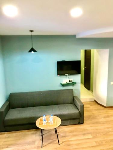 a living room with a green couch and a table at Old Town Mtatsminda in Tbilisi City