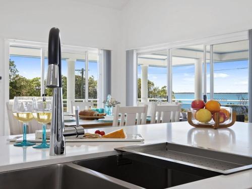 a kitchen with a sink and a counter with a view of the ocean at Bay Views in Callala Bay