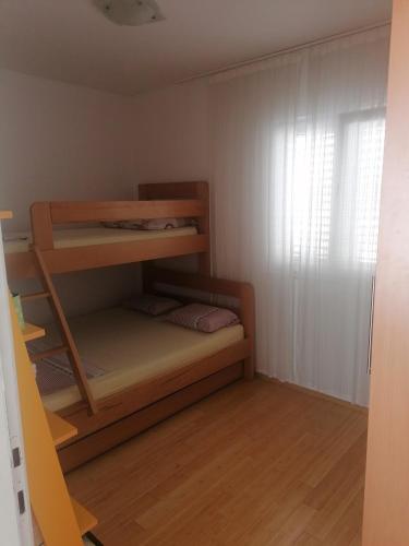 a small room with a bunk bed and a window at Divine view in Donji Seget
