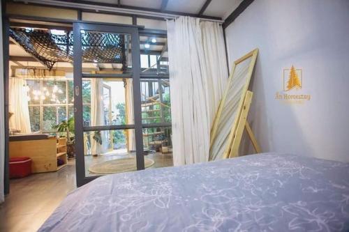 Ẩn Homestay Phan Thiết في Ấp Tân Ðiền (2): غرفة نوم بسرير ونافذة كبيرة