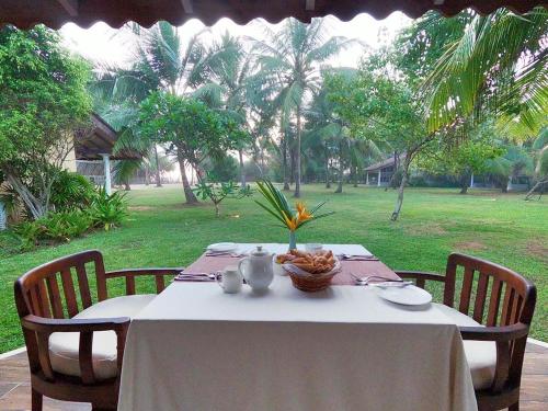 a table with a white table cloth and a bowl of food at The Villas, Wadduwa in Wadduwa
