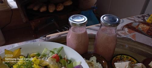 a table with a bowl of salad and two drinks at קטלב kta-love in Kammon
