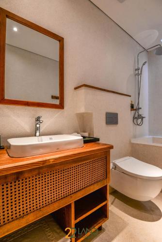 a bathroom with a sink and a toilet and a mirror at 22Land Hotel & Residence in Hanoi