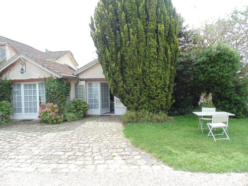 a house with a table and a tree at Clos Saint Nicolas in Neauphle-le-Château