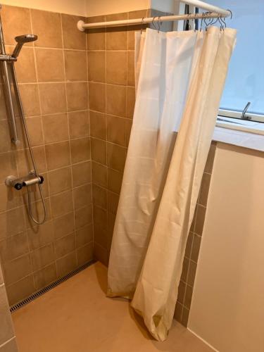 y baño con ducha con cortina blanca. en Second home, en Herlev