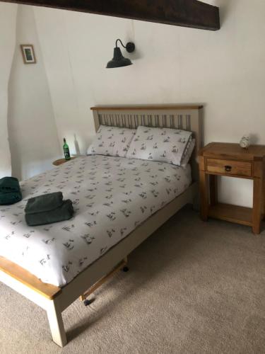 a bedroom with a bed and a wooden nightstand and a bed sidx sidx sidx at Ivy Cottage in Eston