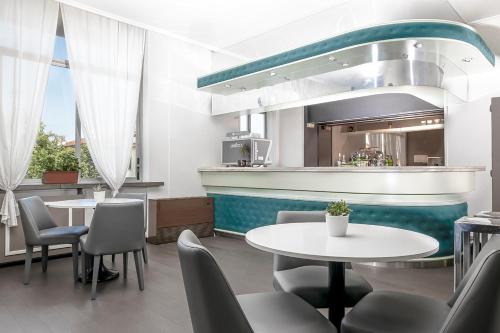 a restaurant with tables and chairs and a kitchen at Hotel Poli in Castelnovo di Sotto