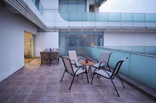 a room with chairs and a table in a building at Regenta Suites Gurugram, Sector 49 Sohna Road in Gurgaon