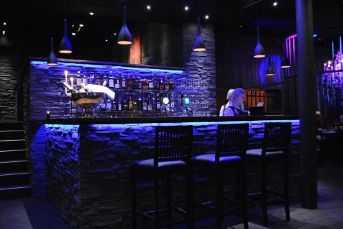 a man sitting at a bar with blue lights at Scandic Arvika in Arvika