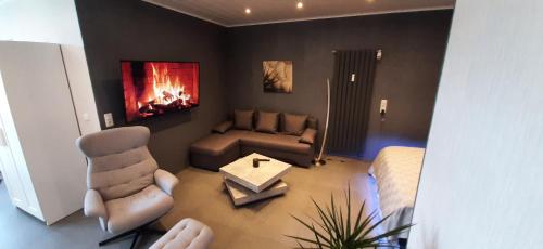 a living room with a couch and a fireplace at Luxus-Appartement II in Übach-Palenberg