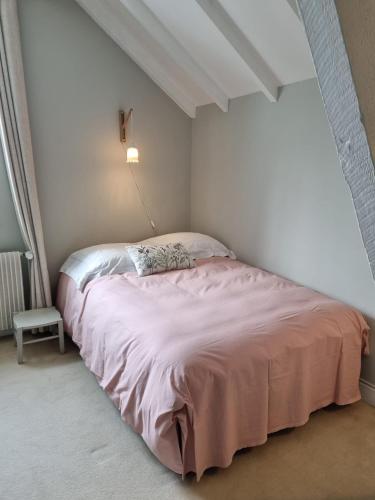 a bedroom with a bed with a pink blanket at La ferme aux grenouilles in Saint-Josse