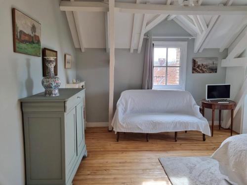 a bedroom with a white bed and a window at La ferme aux grenouilles in Saint-Josse