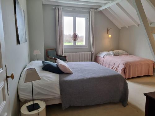a small bedroom with two beds and a window at La ferme aux grenouilles in Saint-Josse
