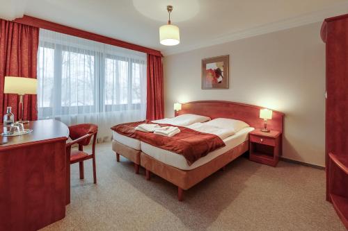 a hotel room with a bed and a desk and a bed sidx sidx sidx sidx at Jagdschloss Waldsee in Waldsee