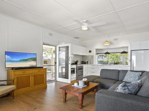 a living room with a couch and a tv at Bellevue in Culburra Beach