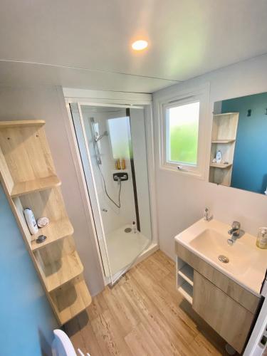 une salle de bain avec douche et lavabo dans l'établissement Mobilhome 6 places vue mer, à Drammont