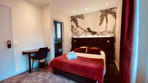 サン・マロにあるHotel Le Croiseur Intra Murosのベッドとデスクが備わるホテルルームです。
