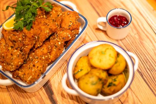 a table with a tray of food and a bowl of potatoes at Komfort Appartements Zirbenland - adults only - no dogs in Weißkirchen in Steiermark