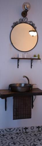 a bathroom with a sink and a mirror on a wall at CavlıHane 1885 in Ayvalık