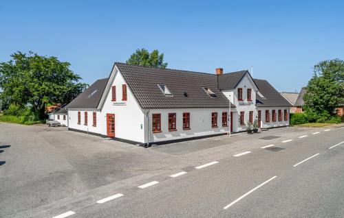 a white building with red windows and a street at Skjoldbjerg Garnihotel in Vorbasse