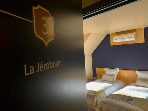 two beds in a room with a sign on the wall at Auberge de Poteaupré in Bourlers