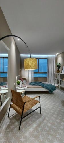 a bedroom with a bed and a bench in a room at Haifa Almog Tower- "Blue Reef" Suite On The Sea in Haifa