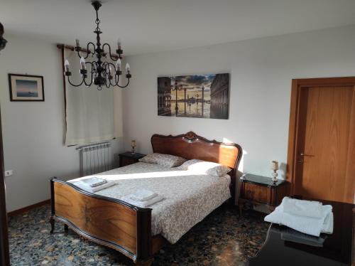 Schlafzimmer mit einem Bett und einem Kronleuchter in der Unterkunft Guizzo apartment Venezia in Venedig